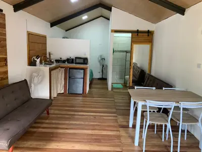 a kitchen and dining room with a table and chairs at Cabañas del Bosque in Nandayure