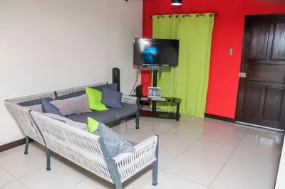 a living room with a couch and a tv at Alojamiento entero 1 km Juan Santamaría Airport in Alajuela City