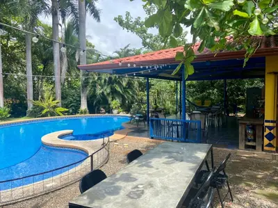 a pool at a resort with a table and chairs at Casa de veraneo Quinta Las Trillizas in Esparza