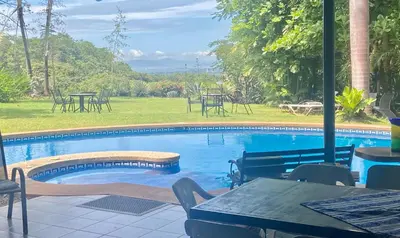 a swimming pool with a table and tables and chairs at Casa de veraneo Quinta Las Trillizas in Esparza