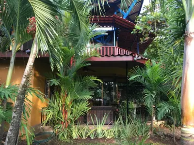 a resort with palm trees in front of a building at Casa de veraneo Quinta Las Trillizas in Esparza