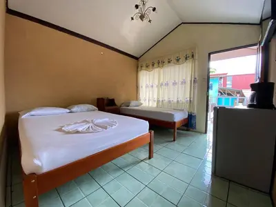 a bedroom with a bed and a tv and a window at Cabinas Las Palmas del Sol in Fortuna