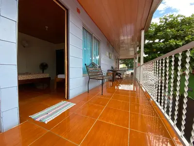 a porch of a house with a wooden floor at Cabinas Las Palmas del Sol in Fortuna