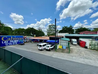 a street with cars parked in a parking lot at Cabinas Las Palmas del Sol in Fortuna