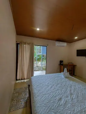 a bedroom with a large bed and a window at Habitación a 26 kilómetros de Jaco, Tulin Azul in Jacó