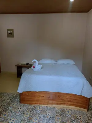 a bedroom with a bed with a swan on it at Habitación a 26 kilómetros de Jaco, Tulin Azul in Jacó
