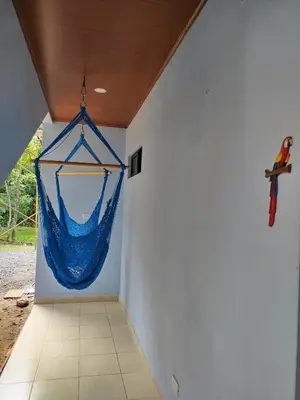 a room with a blue hammock hanging on the wall at Habitación a 26 kilómetros de Jaco, Tulin Azul in Jacó