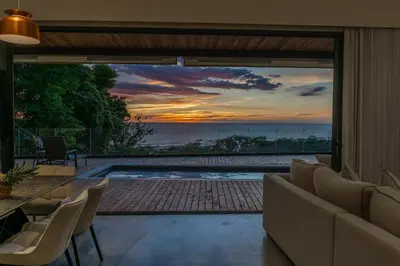 a house with a pool with a view of the sunset at Casa Olala Santa Teresa in Santa Teresa Beach