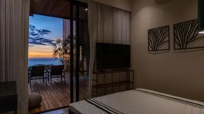 a bedroom with a bed and a view of the ocean at Casa Olala Santa Teresa in Santa Teresa Beach