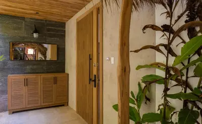 a hallway with a wooden door and a plant at Casa Olala Santa Teresa in Santa Teresa Beach
