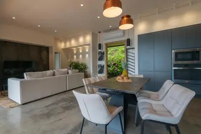 a kitchen and living room with a table and chairs at Casa Olala Santa Teresa in Santa Teresa Beach