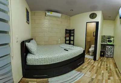 a bedroom with a bed in the corner of a room at Departamento 7 Tortuguero in Tortuguero