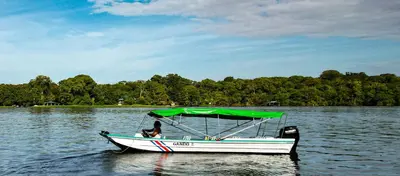 a boat with a green canopy on a lake at Departamento 7 Tortuguero in Tortuguero