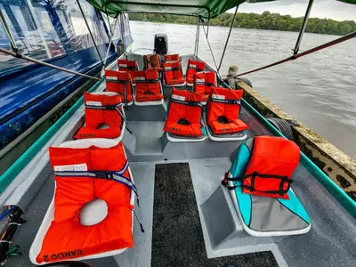a bunch of red seats on a boat in the water at Departamento 7 Tortuguero in Tortuguero