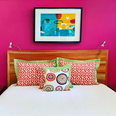 a bedroom with a pink wall and a bed with pillows at Chirripo Art Hotel in Chimirol