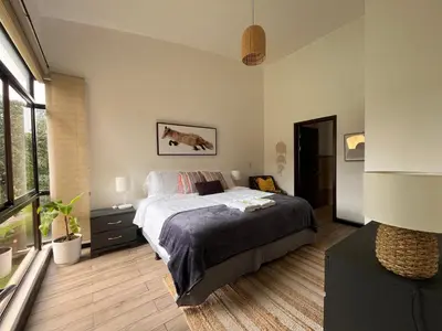 a bedroom with a bed and a large window at CR MARIPOSA RENTALS Lakeview PENTHOUSE with office space, pool, gym, tennis in Santa Ana