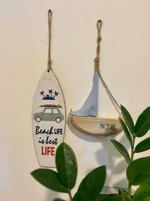a surfboard hanging on a wall with a boat on it at CR MARIPOSA RENTALS Lakeview PENTHOUSE with office space, pool, gym, tennis in Santa Ana