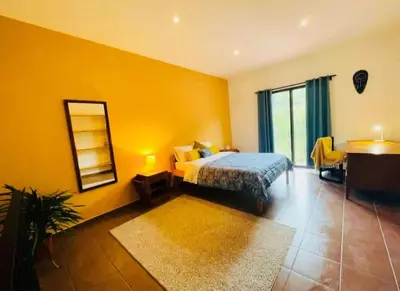 a bedroom with a bed and a mirror and a table at Cozy and Peaceful Beach Apartment in Playa Grande
