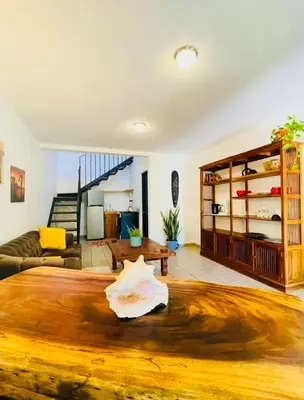 a living room with a wooden table in the middle at Cozy and Peaceful Beach Apartment in Playa Grande