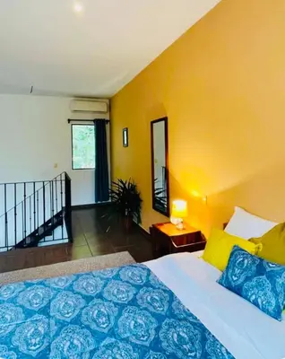 a bedroom with a bed and a yellow wall at Cozy and Peaceful Beach Apartment in Playa Grande