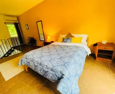 a bedroom with a large bed and yellow walls at Cozy and Peaceful Beach Apartment in Playa Grande