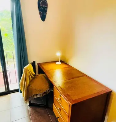 a wooden desk with a candle on top of it at Cozy and Peaceful Beach Apartment in Playa Grande