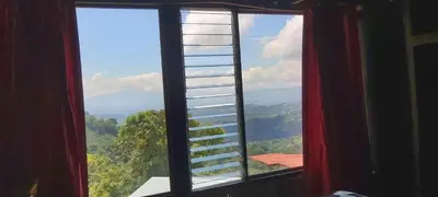 a window with a view of a mountain view at Hospedaje Coffee Mountain in San Isidro