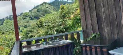 a bathroom with a sink and a view of a mountain at Hospedaje Coffee Mountain in San Isidro