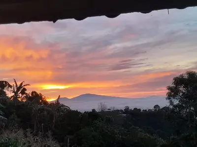 a sunset with a view of the mountains at Hospedaje Coffee Mountain in San Isidro