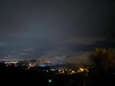 a view of a city at night with lights at Hospedaje Coffee Mountain in San Isidro