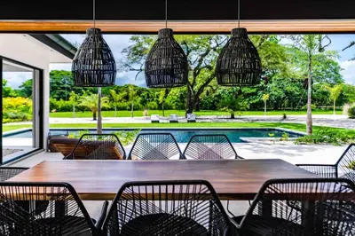 a dining room with a table and chairs and a pool at Villa Twilight Tree 5Bdr Nature & Exclusivity in San José Pinilla