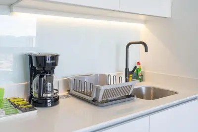 a kitchen counter with a dish drying rack next to a sink at Brand new 1 bed loft with spectacular city view in El Empalme