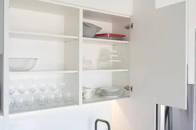 a white cupboard with plates and dishes in it at Brand new 1 bed loft with spectacular city view in El Empalme