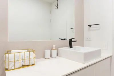a white bathroom with a sink and a mirror at Brand new 1 bed loft with spectacular city view in El Empalme
