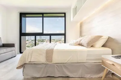 a bedroom with a bed and a large window at Brand new 1 bed loft with spectacular city view in El Empalme