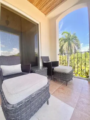 a bedroom with a bed and a chair and a balcony at Peninsula 46 - Upscale 2bdr with Jacuzzi - Beach - Fast wifi - Gym in Tamarindo
