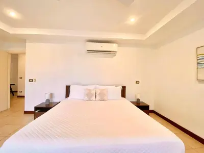 a bedroom with a large white bed with two night stands at Peninsula 46 - Upscale 2bdr with Jacuzzi - Beach - Fast wifi - Gym in Tamarindo