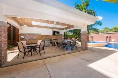 a patio with a table and chairs and a pool at Peninsula 46 - Upscale 2bdr with Jacuzzi - Beach - Fast wifi - Gym in Tamarindo
