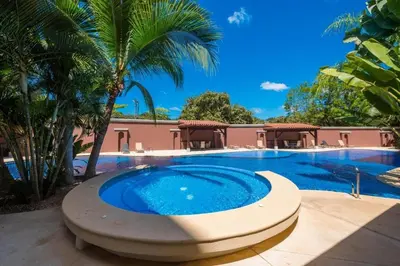 a large swimming pool with a large blue swimming pool at Peninsula 46 - Upscale 2bdr with Jacuzzi - Beach - Fast wifi - Gym in Tamarindo
