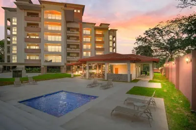 a large building with a swimming pool in front of it at Peninsula 46 - Upscale 2bdr with Jacuzzi - Beach - Fast wifi - Gym in Tamarindo