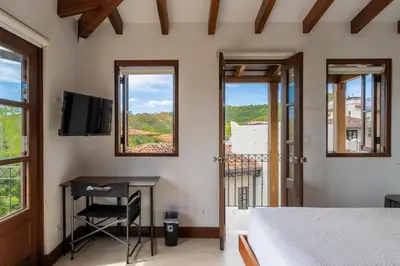 a bedroom with a bed and a desk and windows at Calle Cartagena 14C At Catalinas in Playa Danta
