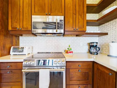 a kitchen with wooden cabinets and a stove top oven at Calle Cartagena 14C At Catalinas in Playa Danta