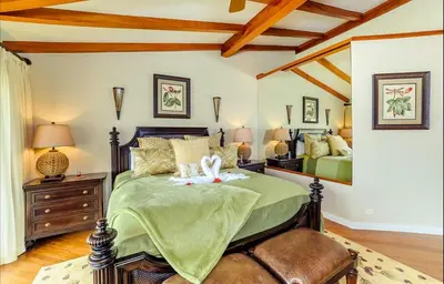 a bedroom with a bed with a green comforter at Palms 20 Luxury Oceanfront Villa in Playa Flamingo