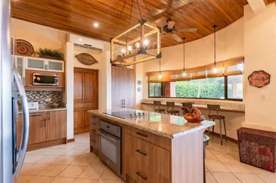 a large kitchen with wooden ceilings and a large island at Casa Rosa- Luxury Ocean View 3 Bedroom Home in Brasilito
