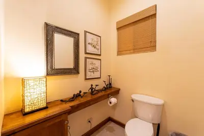 a bathroom with a toilet and a mirror at Casa Rosa- Luxury Ocean View 3 Bedroom Home in Brasilito