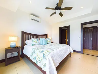 a bedroom with a bed with a ceiling fan at 360 Splendor 307A-Ocean View 2 Br Condo-Breakfast in Playa Flamingo