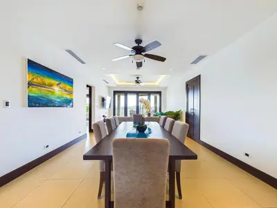 a dining room with a table and a ceiling fan at 360 Splendor 307A-Ocean View 2 Br Condo-Breakfast in Playa Flamingo