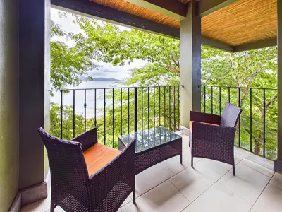 a porch with a table and chairs on a balcony at 360 Splendor 404-Ocean View Condo- With Breakfast in Playa Flamingo