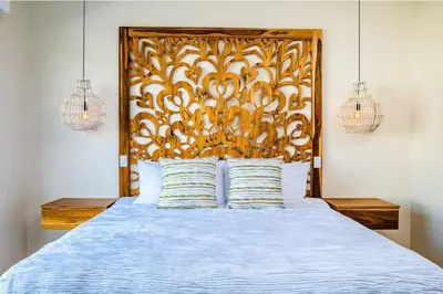a bed with a large wooden headboard and two lights at 8bd Villa ✪ Top Luxury & Exclusive Villa ✪ up to 24 guests in San José Pinilla