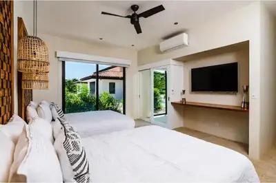 a bedroom with two beds and a flat screen tv at 8bd Villa ✪ Top Luxury & Exclusive Villa ✪ up to 24 guests in San José Pinilla